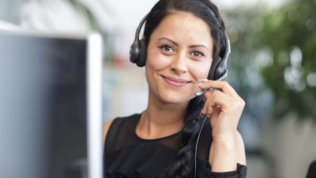 Eine junge Frau im FlexiTel Büro lächelt beim telefonieren