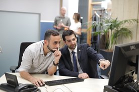 Zwei Kollegen helfen sich gegenseitig im FlexiTel Büro.