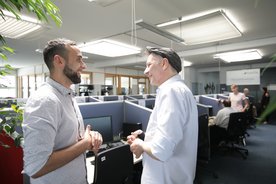 Zwei Kollegen tauschen sich im FlexiTel Büro aus.