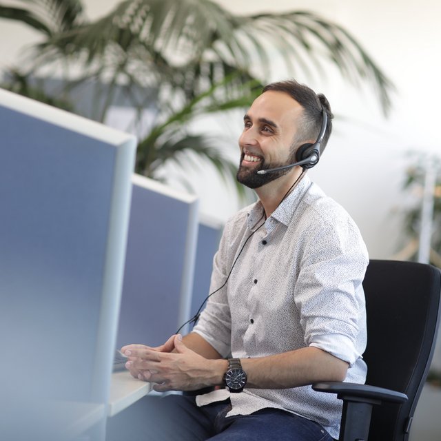 Junger Mann bei FlexiTel hat Spaß auf der Arbeit