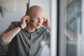 Ein Mitarbeiter mit Headset am Kopf.